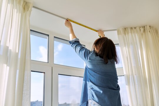 Service For Sewing And Hanging Curtains. Woman With Tape Measure Measuring Window