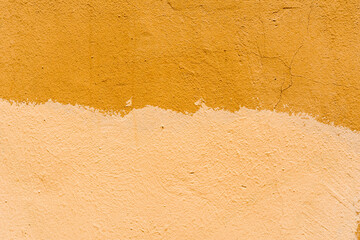 Painted in a yellow rough orange wall. Close up view