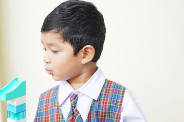 Cute Asian boy about 3 years old wearing a school uniform he has a happy face smile concept. 