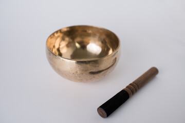 Tibetan Meditation Singing Bowl and wooden mallet next to it. Chacra healing. White background