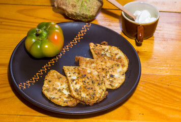 Vegetarian food - celery tuber slices fried in batter in a ceramic plate on a wooden table, close up
