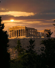sun and fiery sky over Parthenon temple on Acropolis of Athens, Greece