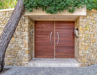 tree trunk and elegant house front entrance natural wood door and stone wall, Athens Greece