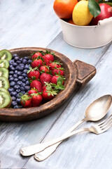 Fresh and various fruits isolated in a shabby chic background. Lemon kiwi banana strawberry blackberry.