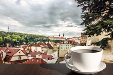 Cup of hot black coffee in cafe with view of street in Prague, Czech Republic. Street with...