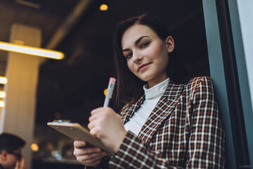 Obraz premium Young woman with clipboard and pen