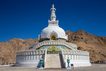 White buddhist stupa or pagoda in tibetan monastery near village Leh in ladakh, noth India - obrazy, fototapety, plakaty