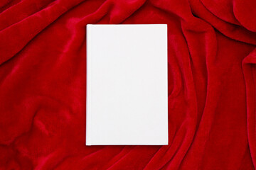 Book with blank cover and empty cover on red blanket