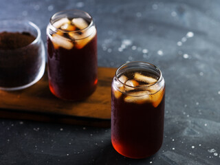 Two glasses of iced coffee . Cold brew in stylish glasses. Dark table copy space