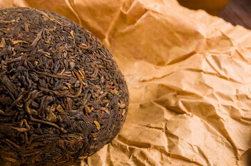 Chinese pressed PU-erh tea on wrapping paper, close-up, macro