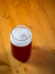 Summer red fruit craft beer sour ale. Stylish glass in the form of a can of beer. Wooden table copy space