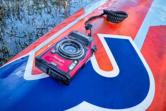 Compact, waterproof Olympus Stylus Tough TG-5 camera on a wet deck of a stand up paddleboard by Mistral
