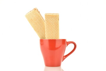 Two sweet vanilla waffles in a red cup, close-up, isolated on white.