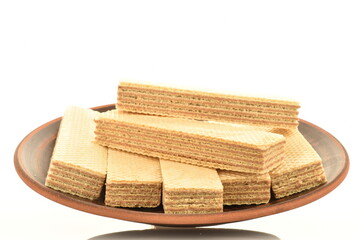 Several sweet vanilla waffles on a clay plate, close-up, isolated on white.