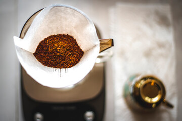 Ground coffee in the filter paper and dripping tool ready to make a coffee.