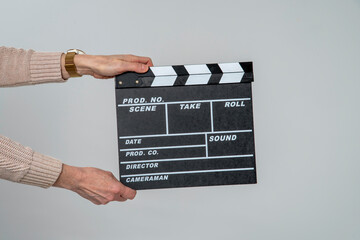 England, UK. 2021. Woman's hands holding a clapper board used to record in white chalk production details in filming.