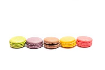 Various flavors of pastel macarons stacked against isolated on white background. Macarons is a delicate meringue-based cookie sandwich It is a dessert of French origin.