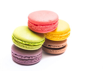 Various flavors of pastel macarons stacked against isolated on white background. Macarons is a delicate meringue-based cookie sandwich It is a dessert of French origin.