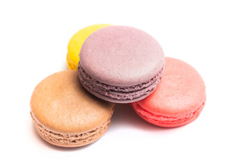 Various flavors of pastel macarons stacked against isolated on white background. Macarons is a delicate meringue-based cookie sandwich It is a dessert of French origin.