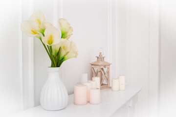Flowers in a vase and candles in the interior..