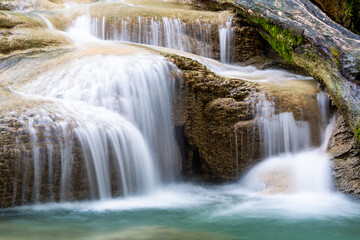 Waterfall and blue emerald water color in Erawan national park. Erawan Waterfall, Beautiful nature rock waterfall steps in tropical rainforest at Kanchanaburi province, Thailand