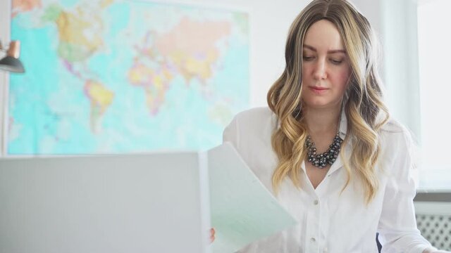 Travel agent working at office with map.