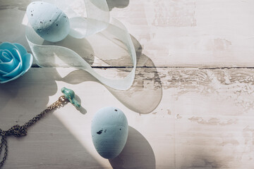 eggs and bird pendant on wooden bg