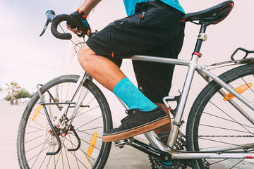 urban cyclist riding a bike in an urban environment. Person on bike with blue t-shirt and socks...