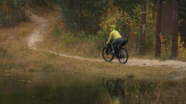 The woman travel on mixed terrain cycle touring with bikepacking. The traveler journey with bicycle bags. Sport tourism bikepacking.
