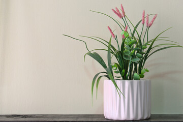 White flowerpot with geometric decoration and artificial Grevillea petrophiloides