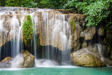 Fototapeta na wymiar Waterfall and blue emerald water color in Erawan national park. Erawan Waterfall, Beautiful nature rock waterfall steps in tropical rainforest at Kanchanaburi province, Thailand