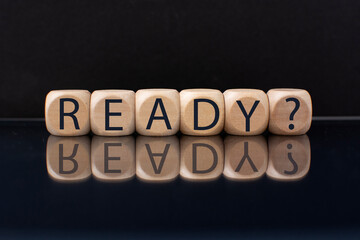 ready word on wooden cubes with a reflection on a black background. Business concept