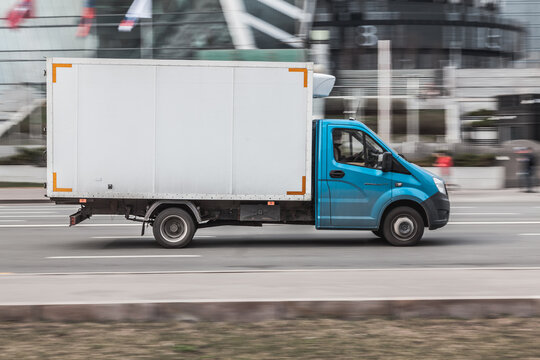 Gazelle rides on the road. White and cyan cargo van GAZ Gazelle Next driving in the street.