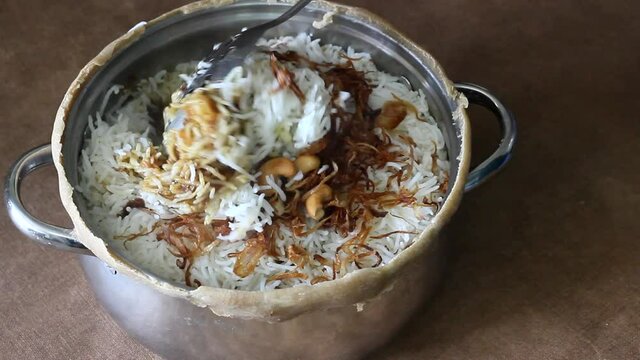 Steamy Mutton biriyani inside the open pot after breaking the sealed edges. The edges were seled for slow cooking the rice for preparing biriyani