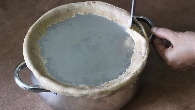 Steams escaping from the pot when the edges are opened using a knife. The edges are sealed using flour dough to slow cook the rice for preparing biriyani
