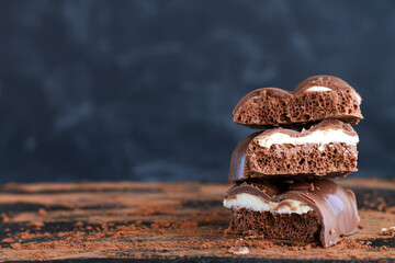 Stack of milk porous aerated chocolate on dark background