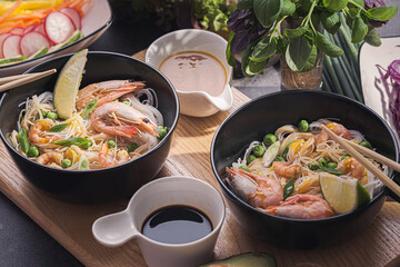Asian dinner for two. Asian cuisine, rice noodles with seafood and vegetables