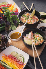 Asian dinner for two. Asian cuisine, rice noodles with seafood and vegetables