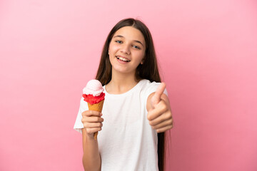 Little girl with a cornet ice cream over isolated pink background with thumbs up because something good has happened