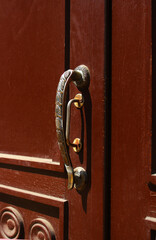 Iron doorknob on a wooden front door.
