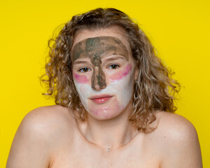 good-natured young beautiful girl with cosmetic mask for healing, cleansing, improving the skin, three colors