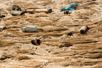 Seile und  Schwimmkörper von Fischernetzen liegen in Kreise und Wellen angeordnet auf dem Strand