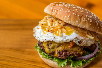 Hamburguesa con huevo frito papas fritas y queso fundido y vegetales frescos