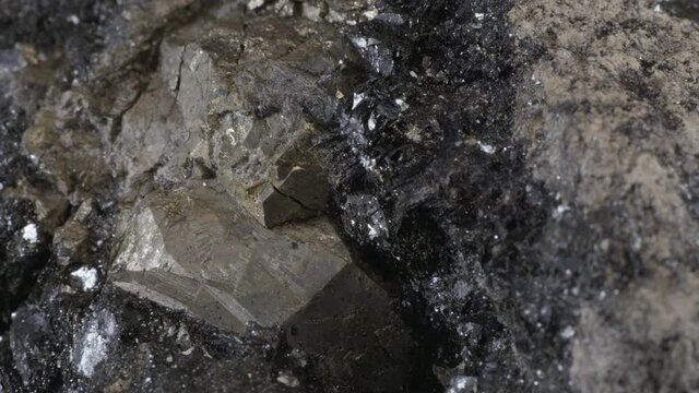 Pyrite dodecahedral crystals on hematite (also known as fool's gold or iron pyrite), isolated on a black background