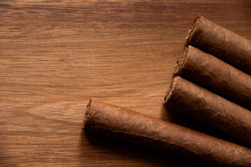Group of brown cuban cigars on wooden background