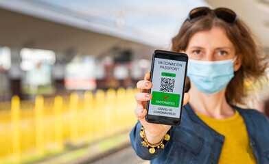 health Vaccine Passport for Coronavirus or Covid-19. Traveller Using Mobile Phone with Vaccination in Immune Status to Certificated International Traveling in train station