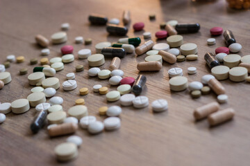 A photo of different medicinal drugs, tablets and pills on wooden background