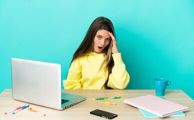 Little girl in a table with a laptop over isolated blue background has realized something and intending the solution