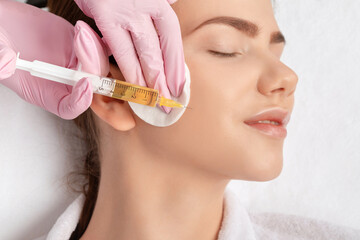 Cosmetologist does prp therapy on the face of a beautiful woman in a beauty salon. Cosmetology concept.