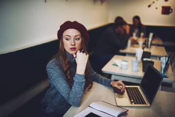 Fototapeta na wymiar Pensive female using laptop during workday